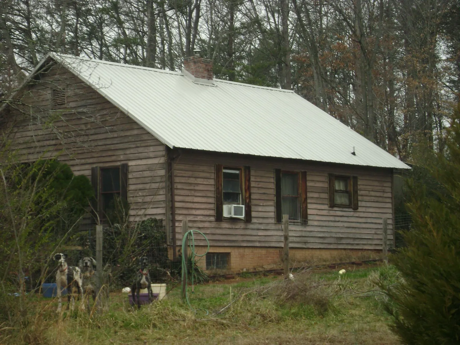 White metal roof on an old wood sided farmhouse, from a Metal Roof Installation job in Rockingham
